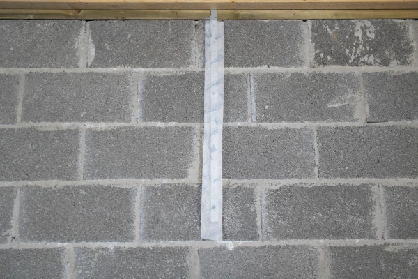 Contega Solido tape over a wall bracket on a masonry wall.