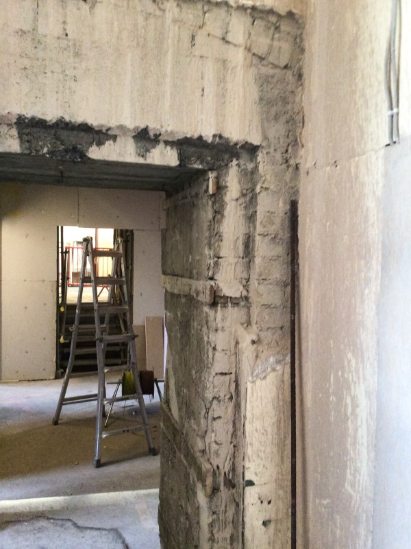 Large section of wall without plaster finish and brick exposed