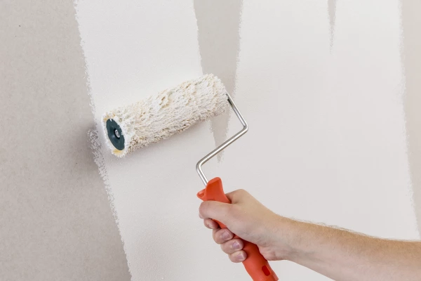White Auro paint being rolled onto a wall