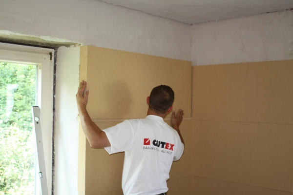 Gutex Thermoroom being stuck onto a wall using a capillary active adhesive