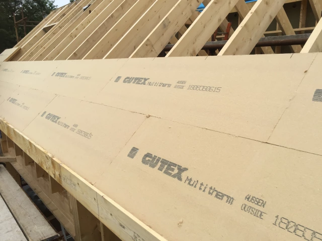 Gutex Multitherm woodfibre boards being fitted over roof rafters. Half completed.