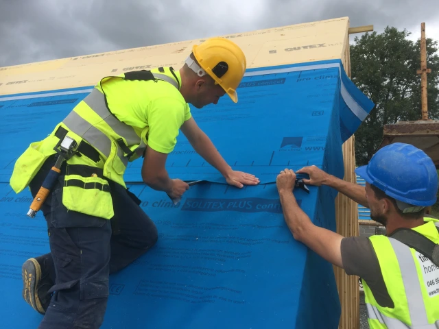 Solitex Plus roofing membrane being attached to The ridge of a roof insulated with Gutex Multitherm woodfibre boards on a roof.