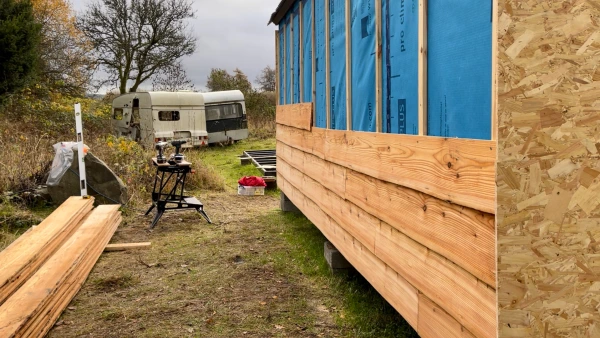 Locally sourced larch cladding boards being applied as a final outside layer.