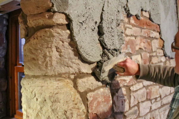 Deumix being appiled with a hand trowel to brick facing