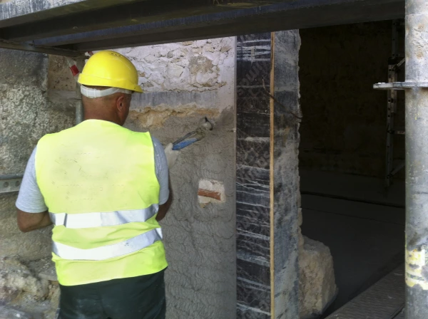 Diathonite Regularisation being spray applied to outer masonry wall