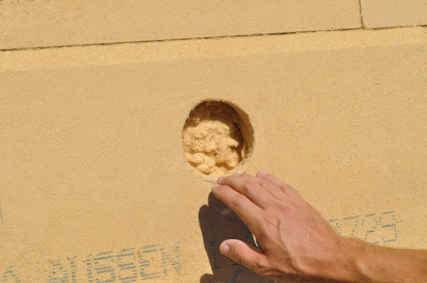 A void in a Gutex insulation board showing Thermofibre after being spray injected into the cavity