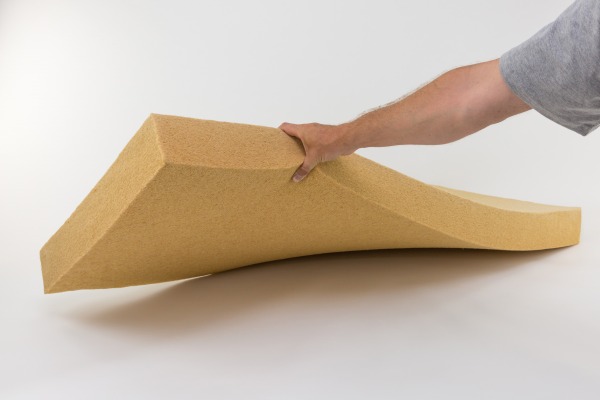A man squeezing a Thermoflex mat to demonstrate its flexibility.