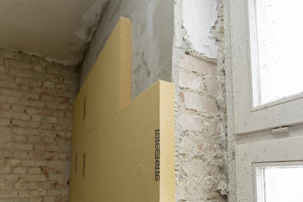 Gutex Thermoroom wood fibre boards bonded to a red brick wall next to a window