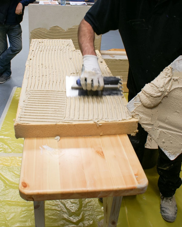 Thermoroom adhesive being applied to a Thermoroom board with an hand trowel