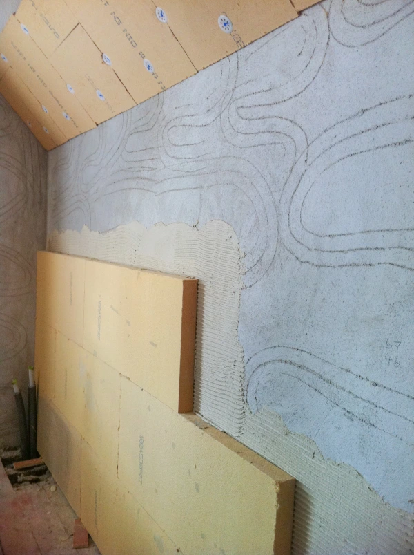 Gutex Thermoroom boards fixed to a solid wall using an adhesive to hold them in place.