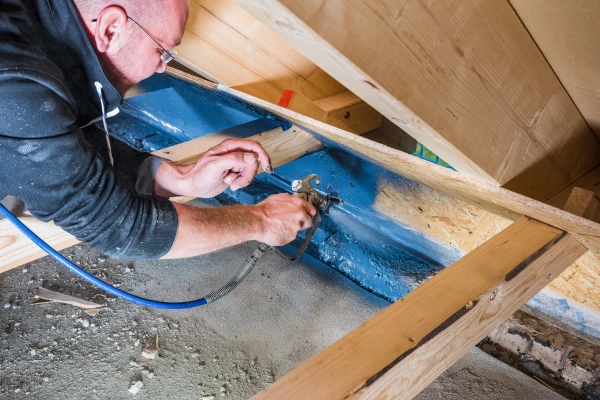 Horizontally spray applying Aerosana Visconn on hard-to-reach timber joists