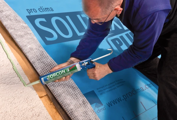 Orcon F being applied on an external wall underneath a sheet of Solitex Plus.