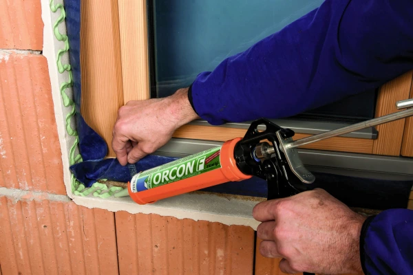 Orcon F being applied to an airtight membrane around a window cill.