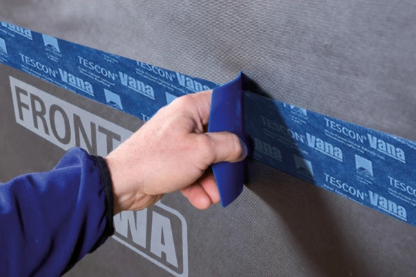 Smoothing down Pro Clima Tescon Vana on to Solitex Fronta WA with a Pressfix Tool.