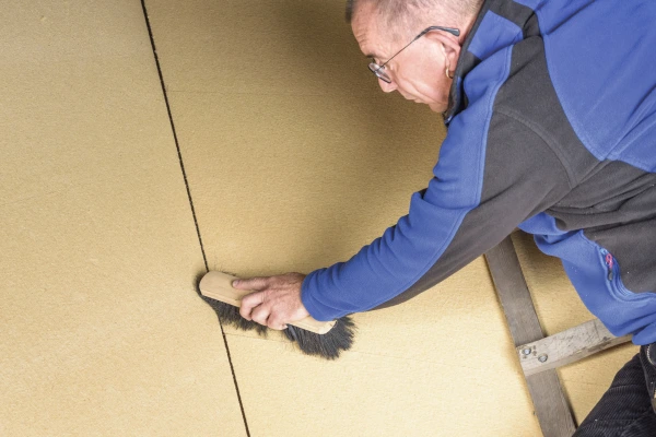 Dust being cleaned off a wall surface using a brush