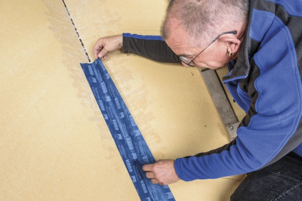 Airtight tape being applied over a junction after being treated with Sprimer