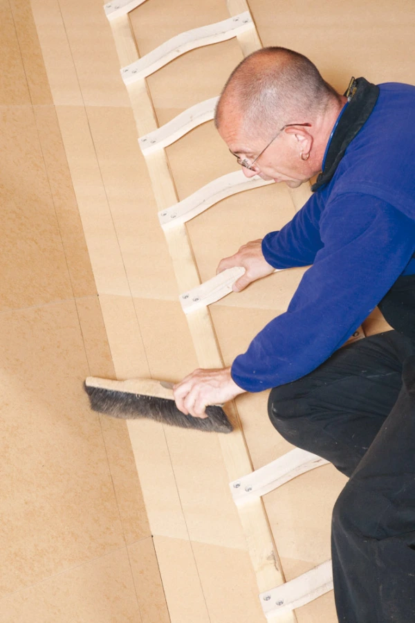 A man cleaning the surface with a brush before applying Tescon Primer