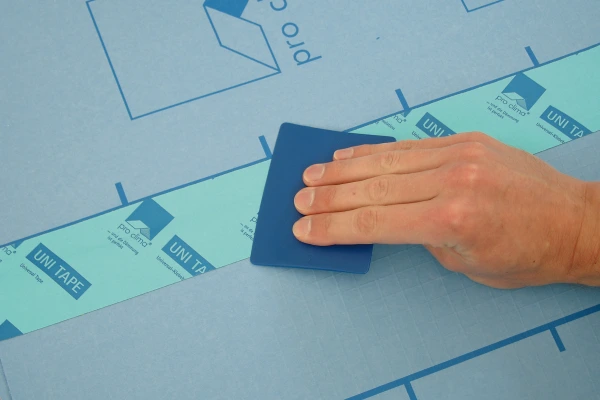 A Pressfix tool being used on Uni Tape to maximize adhesion to an airtight membrane