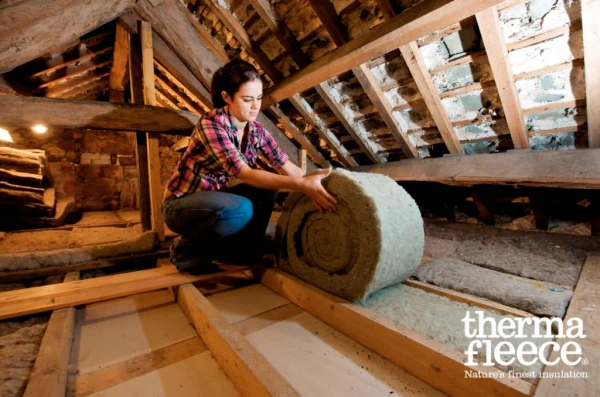 Thermafleece natural sheeps wool insulation being fitted between joists in a loft refurbishment