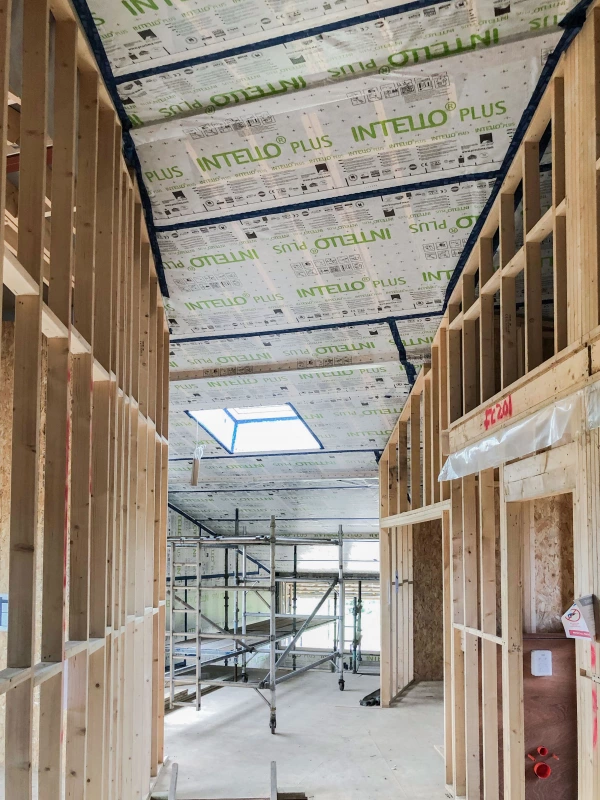 Timber studs separating rooms with Intello Plus airtight membrane on ceiling