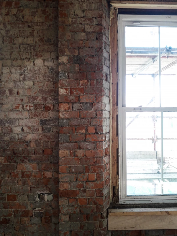 Exposed brickwork around a window prior to Calsitherm boards being installed