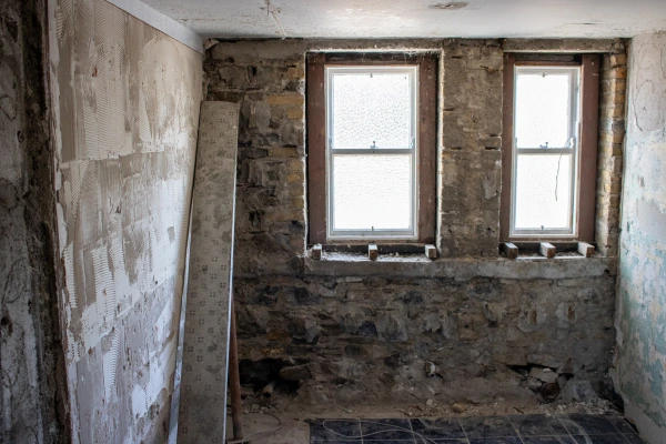 Exposed brick wall featuring two small windows