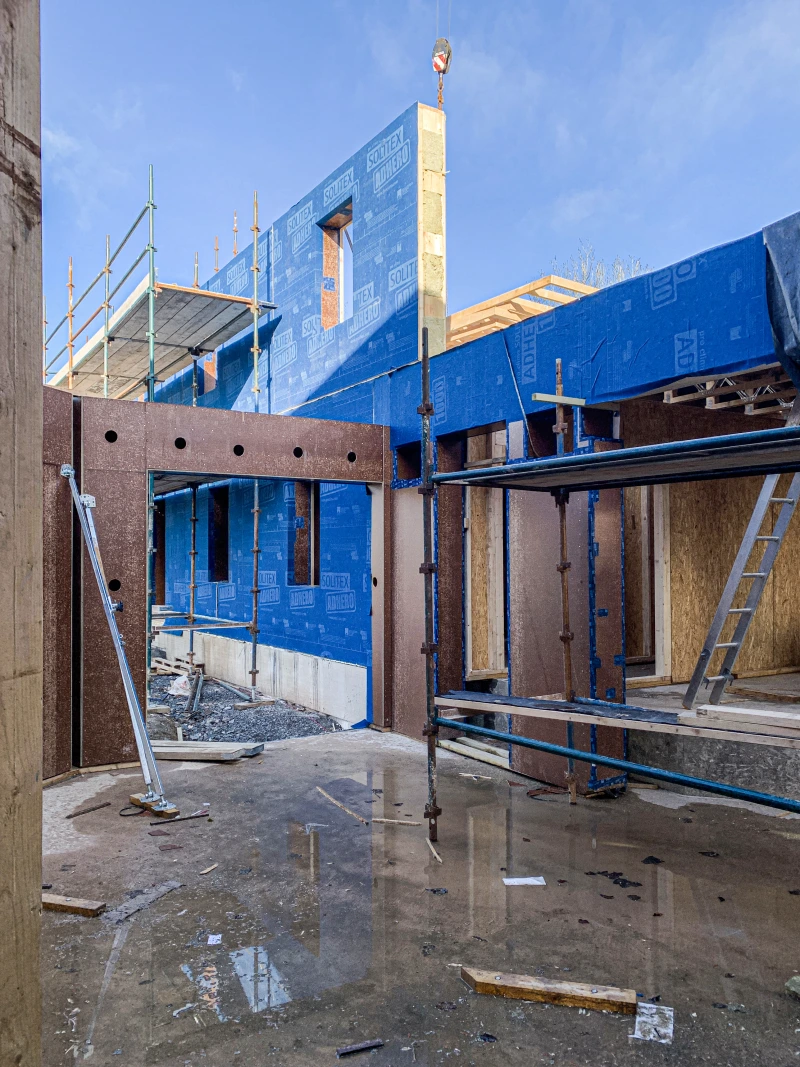 Portrait shot of entranceway with cores drilled in Finsa Superpan Vapourstop racing board from and Solitex Adhero on external wall