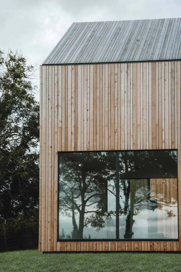 Portrait shot of a large window and larch cladding 