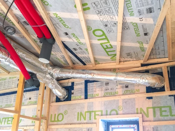 Intello Plus airtight membrane on a timber frame sealed with Tescon Vana airtight tape showing ventilation penetrations through the airtight layer
